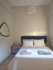 a white bed with a blue headboard and a mirror at In the center of Messolonghi in Missolonghi