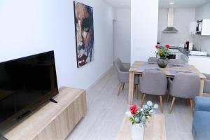 ein Wohnzimmer mit einem TV und einem Tisch mit Stühlen in der Unterkunft Piso Plaza Mercado 2,3 in Salamanca