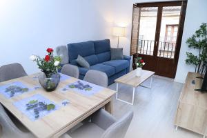 ein Wohnzimmer mit einem blauen Sofa und einem Tisch in der Unterkunft Piso Plaza Mercado 2,3 in Salamanca