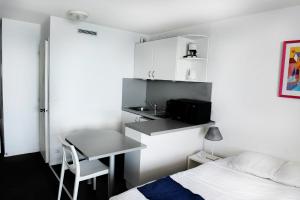 a bedroom with a bed and a desk and a table at BIARRITZ Victoria Surf in Biarritz