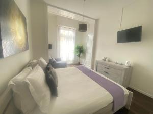 ein weißes Schlafzimmer mit einem Bett und einem Fenster in der Unterkunft B&B Guest House Du Lac in Montreux
