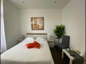 una camera con un letto bianco e un cuscino rosso di B&B Guest House Du Lac a Montreux