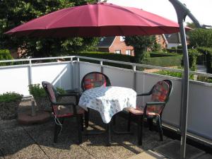 a table and chairs under an umbrella on a patio at Ferienwohnung Novotny in Jerrishoe