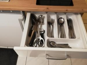 a drawer filled with utensils in a cabinet at Ferienwohnung Juco in Heddesheim