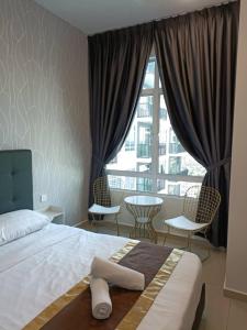 a bedroom with a bed and chairs and a large window at D' Cozy Premium @ Novo 8 Residence in Melaka