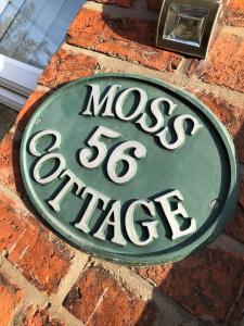 Willaston的住宿－Moss Cottage，砖墙边的标志