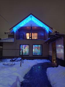 a house with blue lights on it in the snow at Северная Звезда in Saint Petersburg