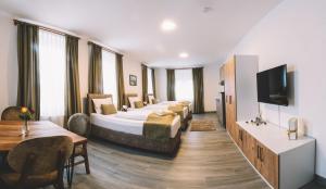 a hotel room with two beds and a flat screen tv at E&B Aparthotel in Korb