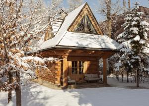une cabane en rondins avec un toit recouvert de neige dans l'établissement Domek Pod Lipkami, à Zakopane
