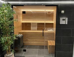 La salle de bains est pourvue d'un sauna avec une porte en verre. dans l'établissement Bed en Wellness de Paauw, à IJzendijke