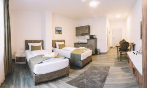 ein Hotelzimmer mit zwei Betten und einem Badezimmer in der Unterkunft E&B Hotel Korb bei Waiblingen & Stuttgart in Korb