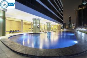 a large pool in the middle of a city at night at The Four Wings Hotel Bangkok in Bangkok
