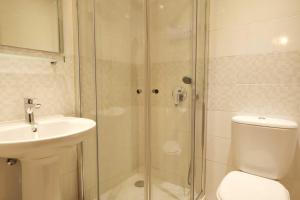 a bathroom with a shower and a toilet and a sink at 3B Waterside in Luz