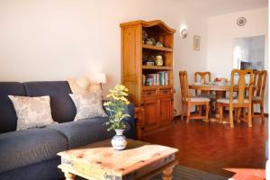 a living room with a blue couch and a table at 3B Waterside in Luz
