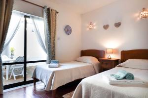 a bedroom with two beds and a balcony at 3B Waterside in Luz