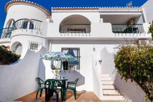 a house with a table and chairs in front of it at 3B Waterside in Luz
