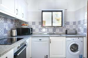 a kitchen with a sink and a washing machine at 3B Waterside in Luz +6 photos