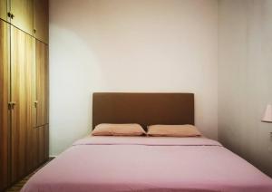 a bedroom with a large bed with pink sheets at Cozy NEAR-BEACH Apartment - LazyCats' Den in Batu Ferringhi