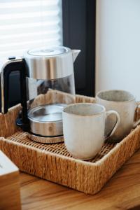 a tray with three cups and a coffee maker on a counter at Village Turmzimmer in Kehl am Rhein +30 photos