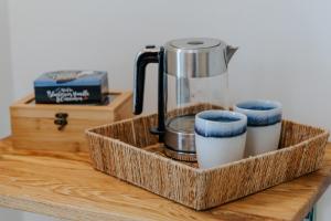 a wooden tray with a coffee maker and three cups at Village Turmzimmer in Kehl am Rhein