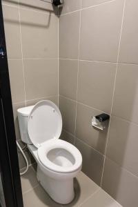 a bathroom with a white toilet in a stall at M Cabin Karawaci in Binong