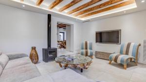 a living room with a couch and a table and a tv at Number 11 in Pollença