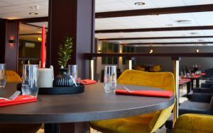 uma mesa num restaurante com copos e cadeiras em Rjukan hotell em Rjukan
