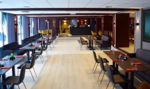 a restaurant with tables and chairs and a stage at Rjukan Hotell in Rjukan