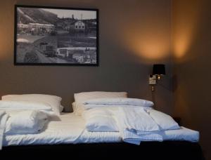 a bed with white sheets and pillows in a room at Rjukan Hotell in Rjukan
