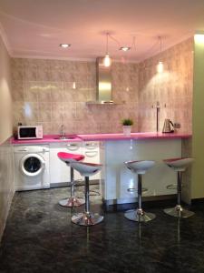 a kitchen with a counter and three bar stools at Hotel Artetxe in Bilbao +55 photos