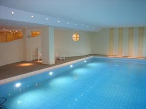 een groot blauw zwembad in een hotelkamer bij App-Stadtoase-Haus-Nordland in Westerland