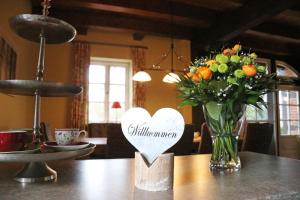 un vaso di fiori e un cuore su un tavolo di Ferienhaus Viebrock 