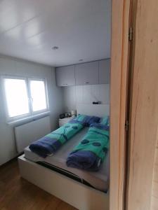a bedroom with a bed with blue pillows on it at Tiny House am Wald in Krina
