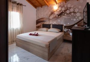 - une chambre avec un grand lit fleuri dans l'établissement ViLLA DRAGANI, à Sikia