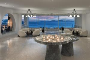 a living room with a table with candles on it at Mykonos Grand Hotel & Resort in Agios Ioannis Mykonos