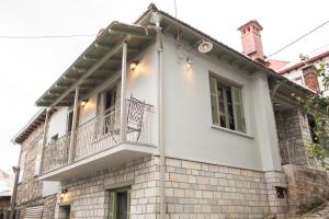 a white house with a balcony on top of it at Dandy Villas Metsovo-Metska-Down Town-Up to 7 in Metsovo