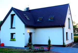 una casa blanca con techo negro en Pokoje Gościnne u Kovi, en Legnica