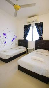 a bedroom with two beds and a window at Palm Court in Tanjong Tokong
