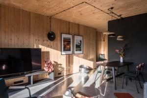 a living room with a large television and a table at Pförtner Penthouse in Hausham