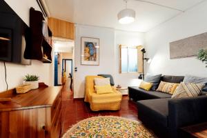 ein Wohnzimmer mit einer Couch und einem Sessel in der Unterkunft Alohamundi San Basilio in Sevilla