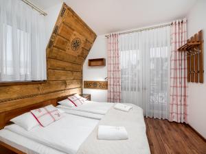 マウェ・チヘにあるWilla Pod Reglami - Małe Ciche 39 - w ogrodzie Balia z Jacuzziのベッドルーム1室(白いシーツと赤い枕のベッド2台付)