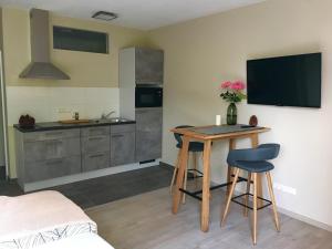 cocina con mesa y TV en la pared en 2nd Home Appartements 23, en Nieder-Olm