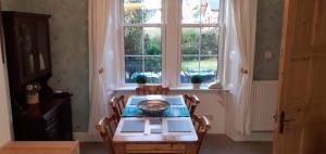 a dining room with a table and a window at Andreu Cottage in Callander