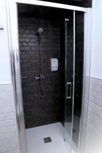 een douche in een badkamer met een bakstenen muur bij Ático Plaza Mercado 4,5 in Salamanca +24 foto's
