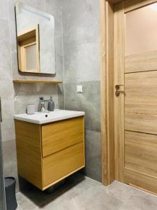 a bathroom with a sink and a mirror at Apartament Przytulny in Kołobrzeg
