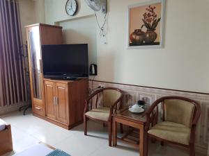 ein Wohnzimmer mit einem TV, 2 Stühlen und einem Tisch in der Unterkunft Khách Sạn Hương Sơn in Bắc Giang
