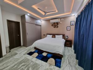 a bedroom with a bed and a blue curtain at The Urban Nest in Bangalore