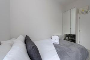 a bedroom with a white bed with pillows at Fabulous Apartment in Superb location in London
