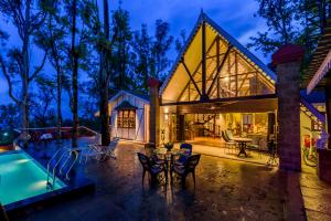 einen Blick nach außen auf ein Haus mit einem Pool in der Unterkunft SaffronStays Tudor Rose, Panchgani - luxury chalet with beautiful valley views in Panchgani