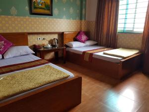 ein Hotelzimmer mit 2 Betten und einem Fenster in der Unterkunft Khách Sạn Hương Sơn in Bắc Giang